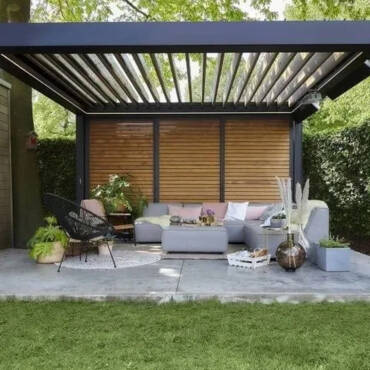 Custom black aluminium louvres installed in a sunny Auckland backyard, creating a comfortable and stylish outdoor living space.