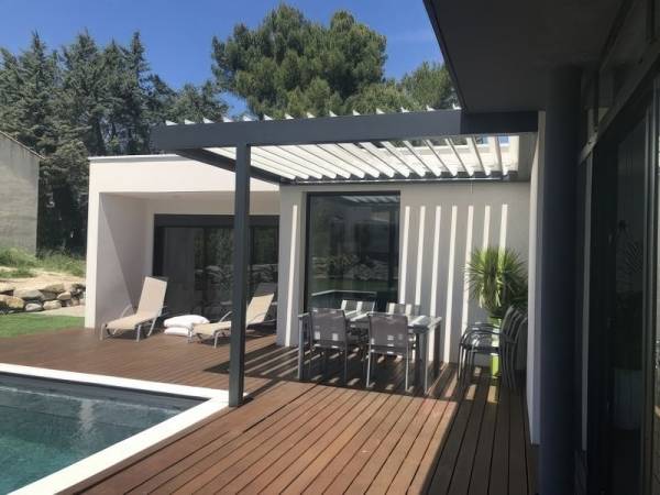 Homelovers: White, freestanding louvre roof with half-open slats installed poolside at an Auckland luxury home.